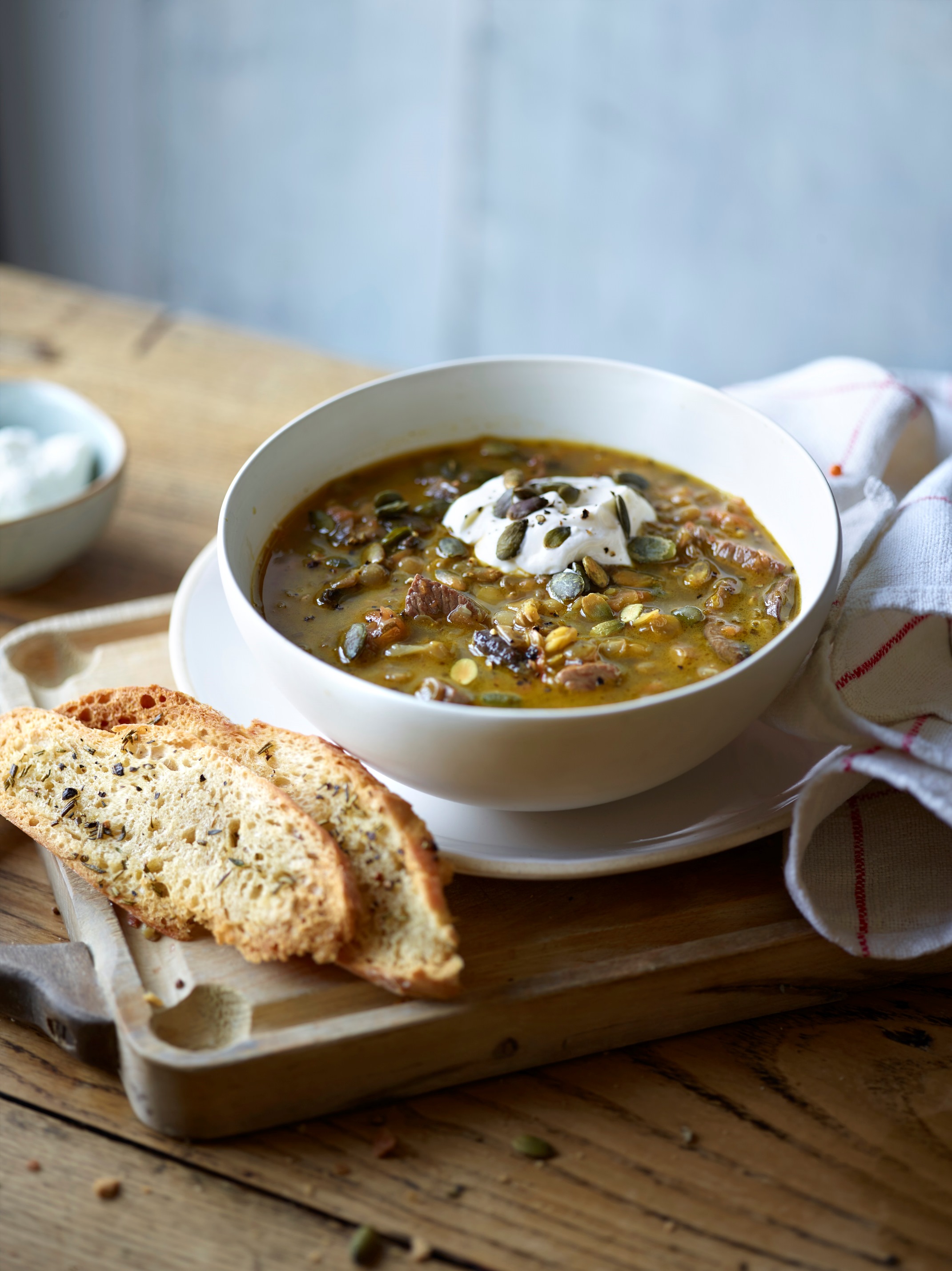 Hearty and chunky lamb and lentil soup with herbed croutons, yoghurt and pumpkin seeds by Peter Gordon